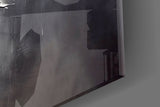 Graphite-and-gold feather glass wall art in boutique-hotel lounge