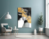 Gold-and-charcoal woman cinematic glass wall art in boutique-hotel lounge
